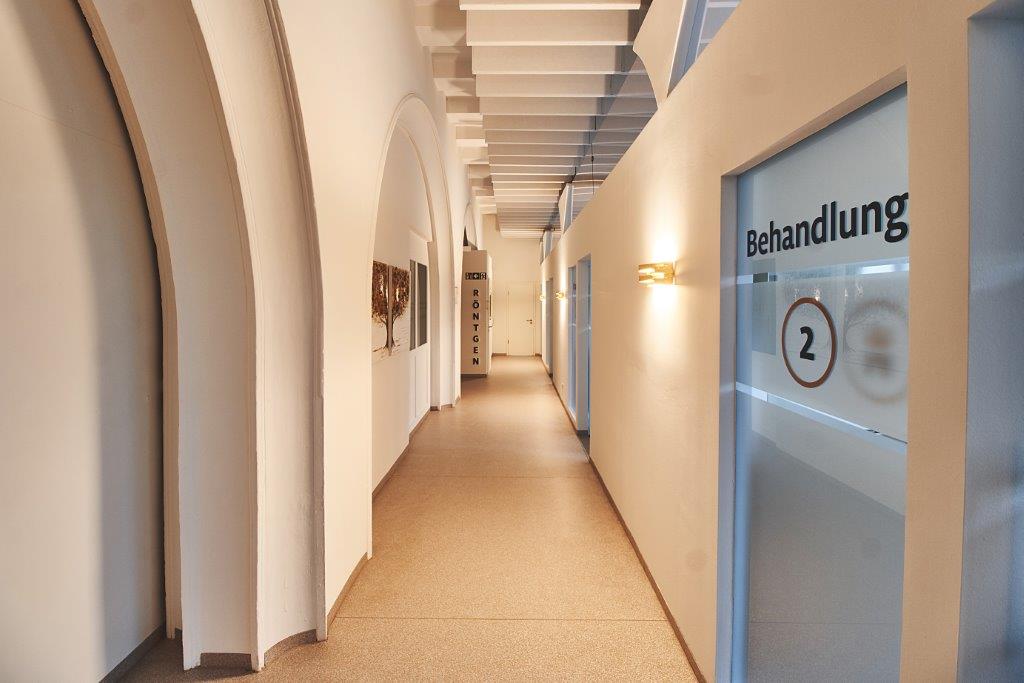 Praxisflur mit Trockenbauwänden, Lamellendecke und Beschilderung der Behandlungsräume